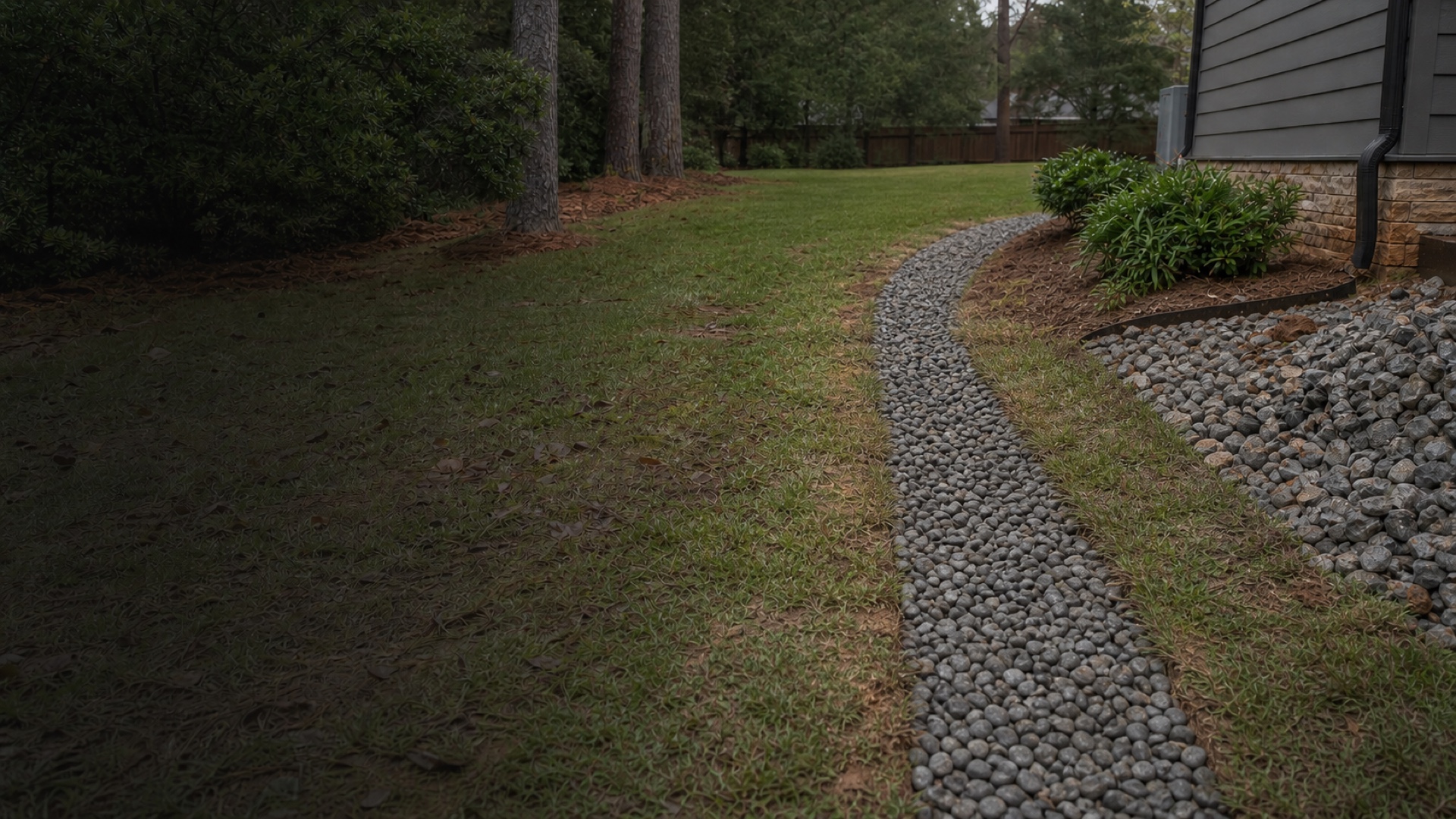 The same yard after the French drain route is finished with a clean stone surface